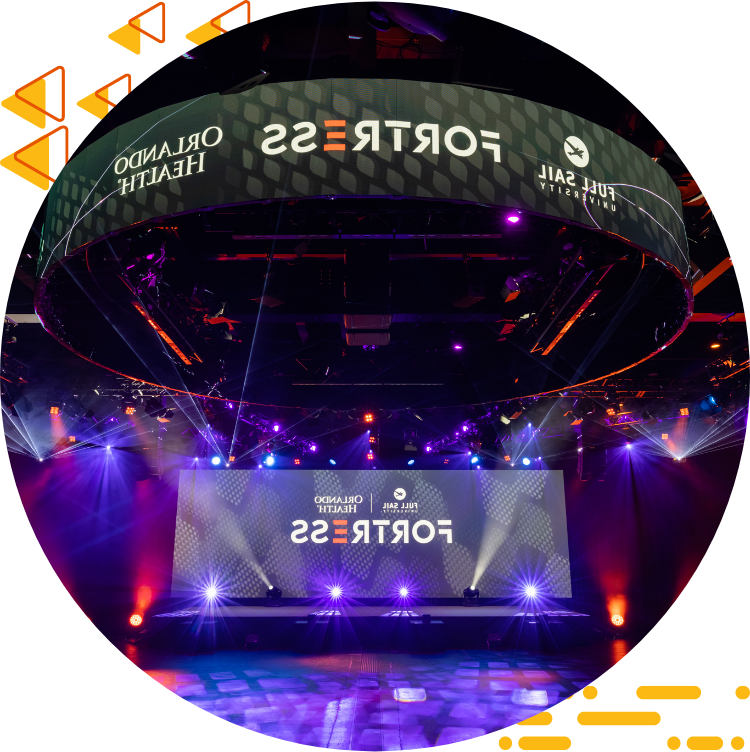 全帆奥兰多健康堡垒的照片, with spotlights and multiple display screens containing logos for the esports space.